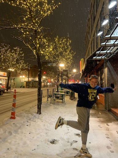 girl on sidewalk posing under the holiday lights in downtown Ann Arbor