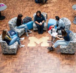 A faculty member meeting with a group of students